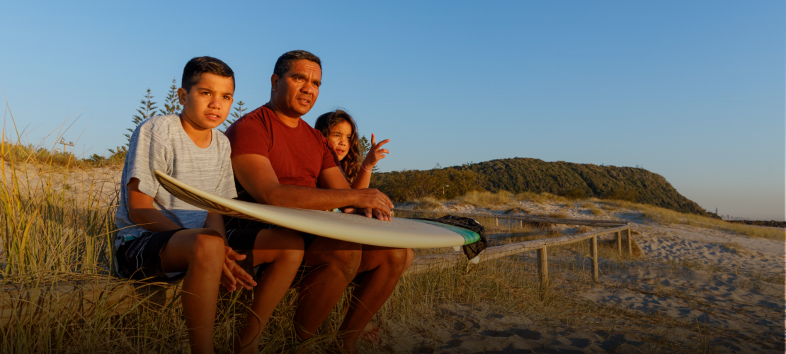 Family on a beach with surfboards