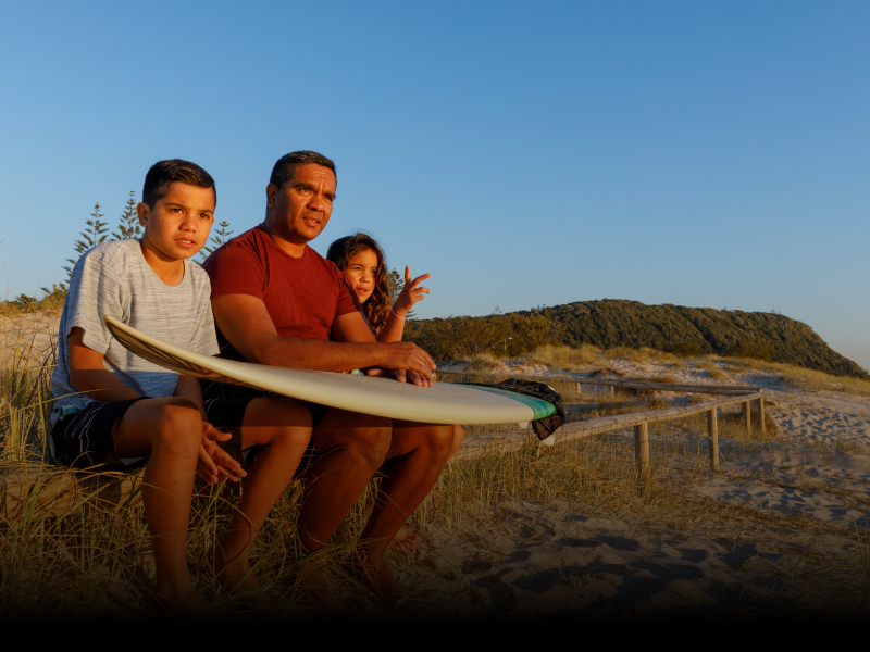 Family on a beach with surfboards